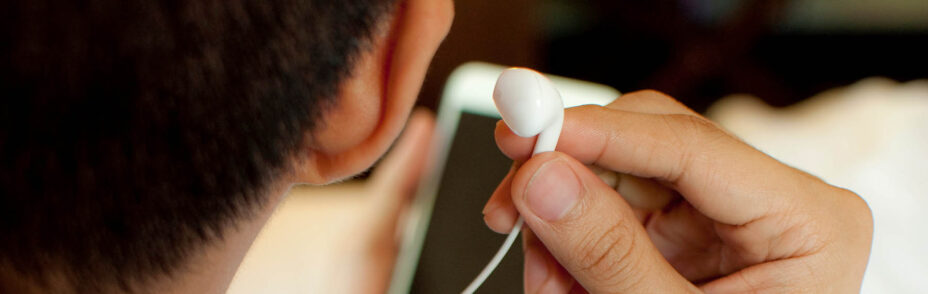 Photo of a man listening to a podcast